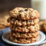 Homemade Quaker Oatmeal Cookie Recipe on a white plate, golden-brown with oats and raisins, crisp edges, soft centers, cozy kitchen feel.