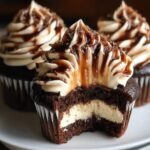 Homemade chocolate coffee cream cupcakes with creamy filling, espresso frosting, and chocolate drizzle, shown close-up on a plate.