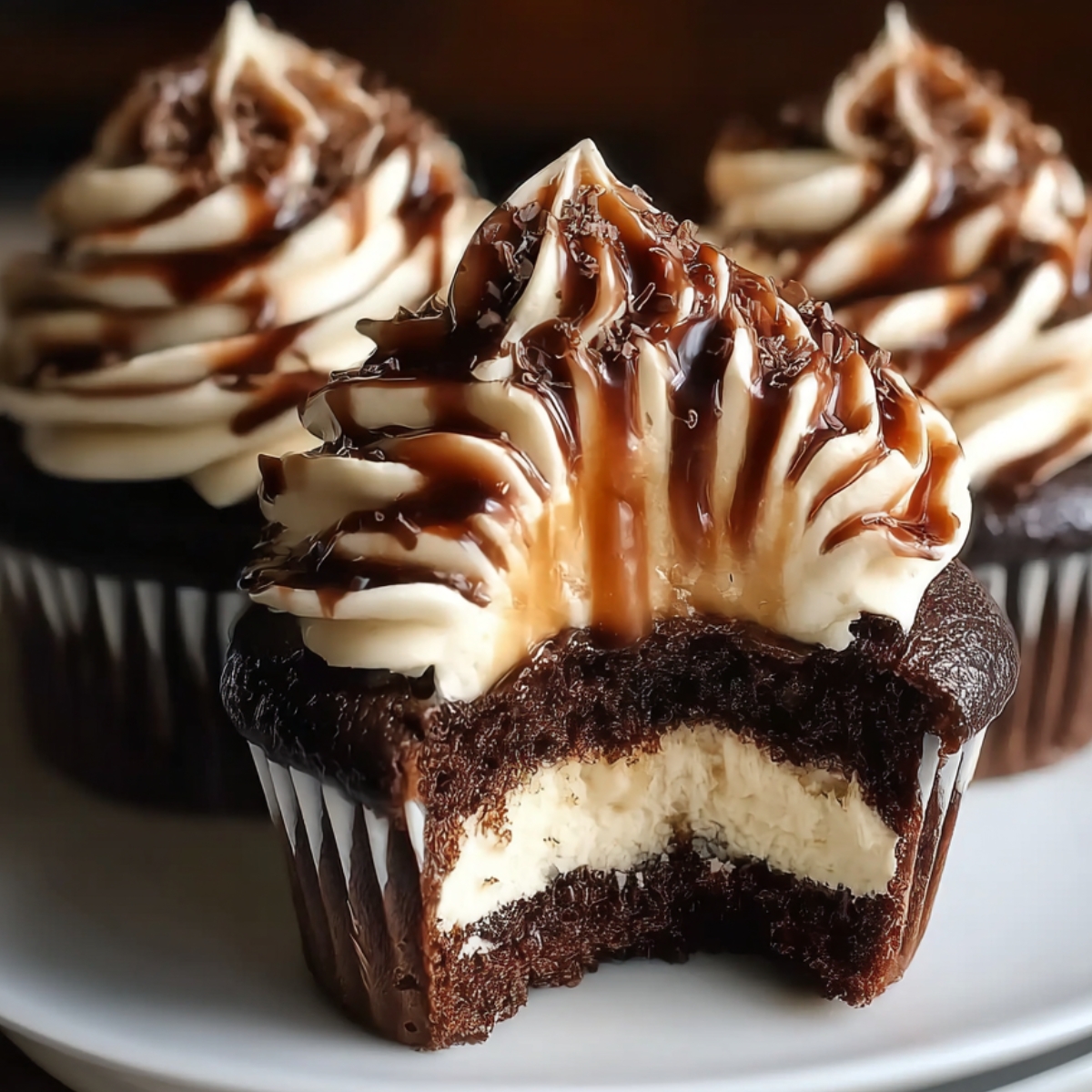 Homemade chocolate coffee cream cupcakes with creamy filling, espresso frosting, and chocolate drizzle, shown close-up on a plate.