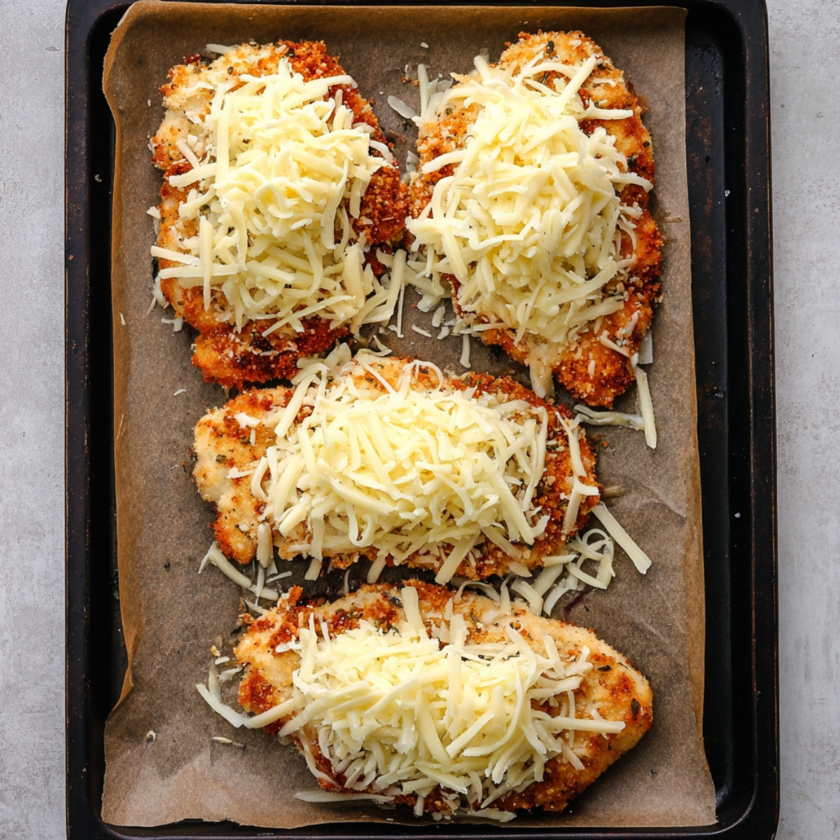 Place all four chicken cutlets on your prepared baking sheet. In a small bowl, mix together the mozzarella and Monterey Jack cheeses. Spoon a small mound of the cheese mixture onto each piece of chicken. Slide the pan into the oven and bake for 13 to 15 minutes, until the internal temperature hits 165°F and the cheese is melted and bubbly.