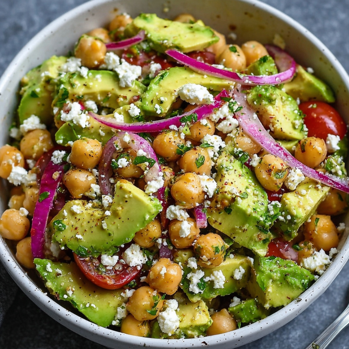 Homemade Chickpea Feta Avocado Salad with cherry tomatoes, red onion, and fresh herbs tossed in a lemon dressing.