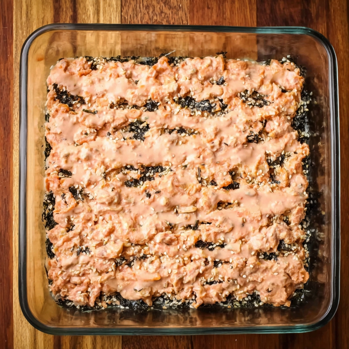 Spread the creamy salmon mixture evenly over the rice layer. It should cover the rice completely, edge to edge.