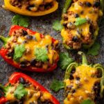 A delicious close-up of Bell Pepper Nachos halves stuffed with seasoned ground beef, black beans, corn, and melted cheese, garnished with fresh cilantro.
