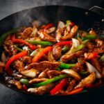 Spicy Black Pepper Chicken stir fry with vegetables, glossy sauce, cooking in a pan