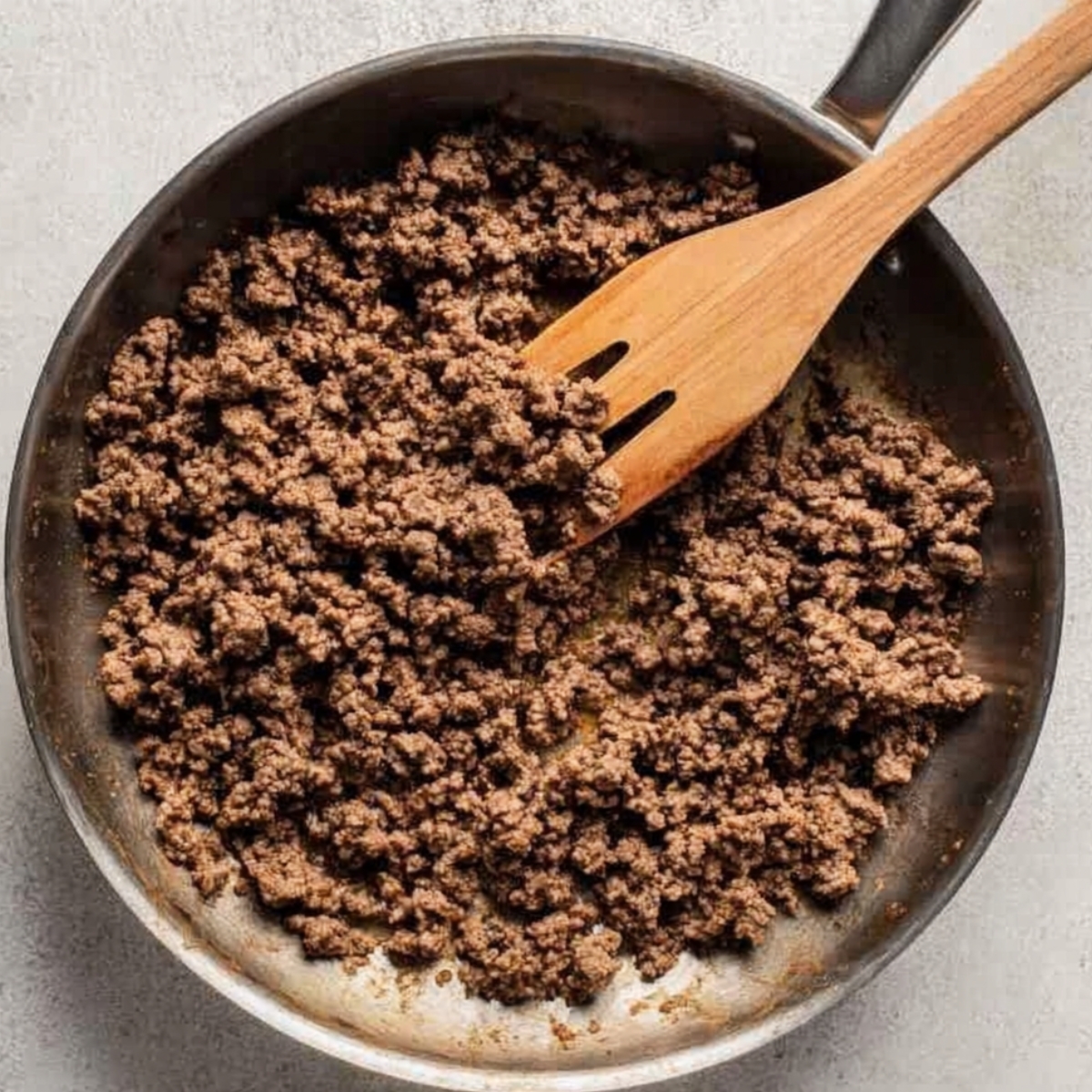 Heat a large wok or skillet over medium-high heat and add a small drizzle of oil. Once it's hot, add the ground beef and break it up with a wooden spoon or spatula. Cook for about 5 to 7 minutes, stirring occasionally, until the beef is browned and no longer pink. You want some nice caramelization on the edges.