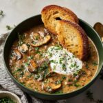 Creamy Hungarian Mushroom Soup with sliced mushrooms, sour cream, herbs, and toasted bread slices.