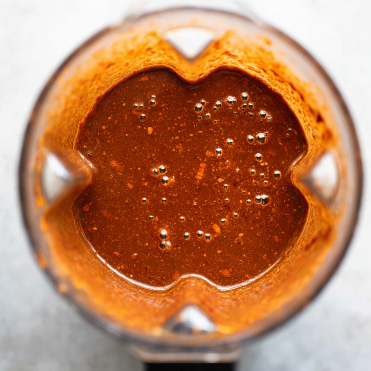 A blended, rich red chili sauce in a blender.
