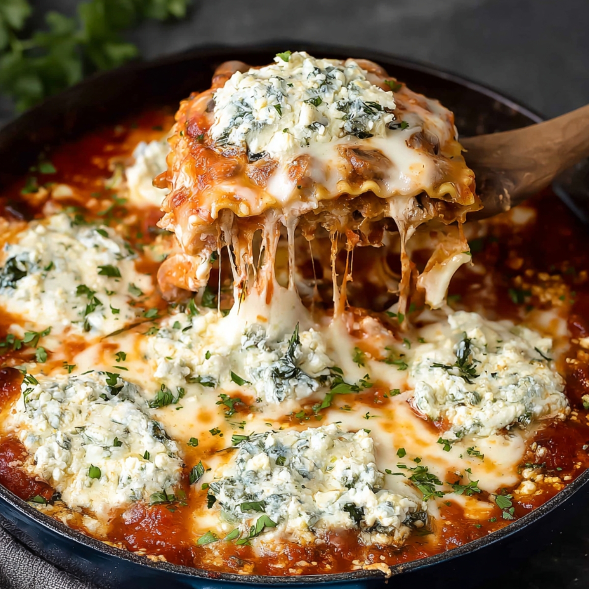 A hearty serving of Mushroom alla Vodka Stovetop Lasagna with melted cheese and spinach filling, served with a wooden spatula lifting a cheesy layer.