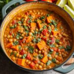 Sweet Potato Chickpea Curry with cilantro in a rustic pot.