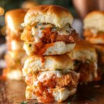 Stacked Buffalo Catfish Sliders with crispy fried fish fillets, buffalo sauce, and melted cheese, served in soft buns.